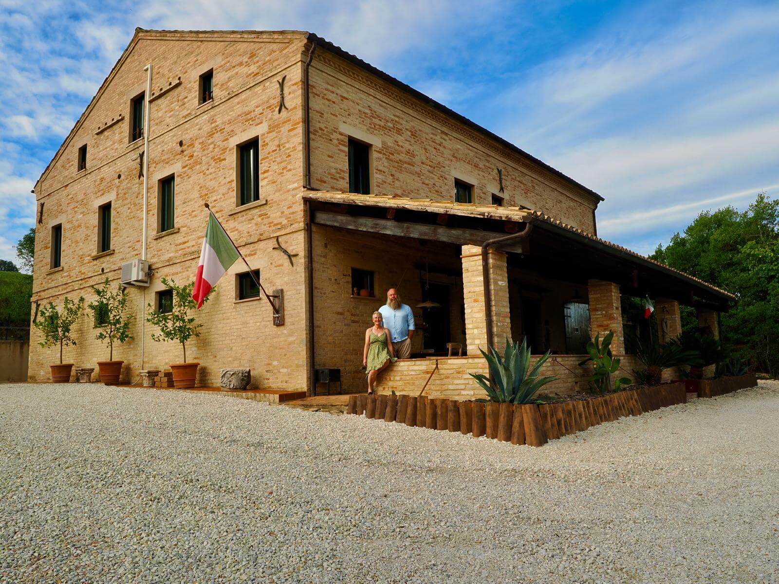 Vooraanzicht van B&B La Villa angelica met de eigenaren op de portico.